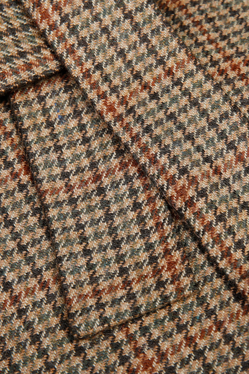 Close-up of a textured fabric with a checkered pattern in brown, beige, and black. office wear for her, business wear for women