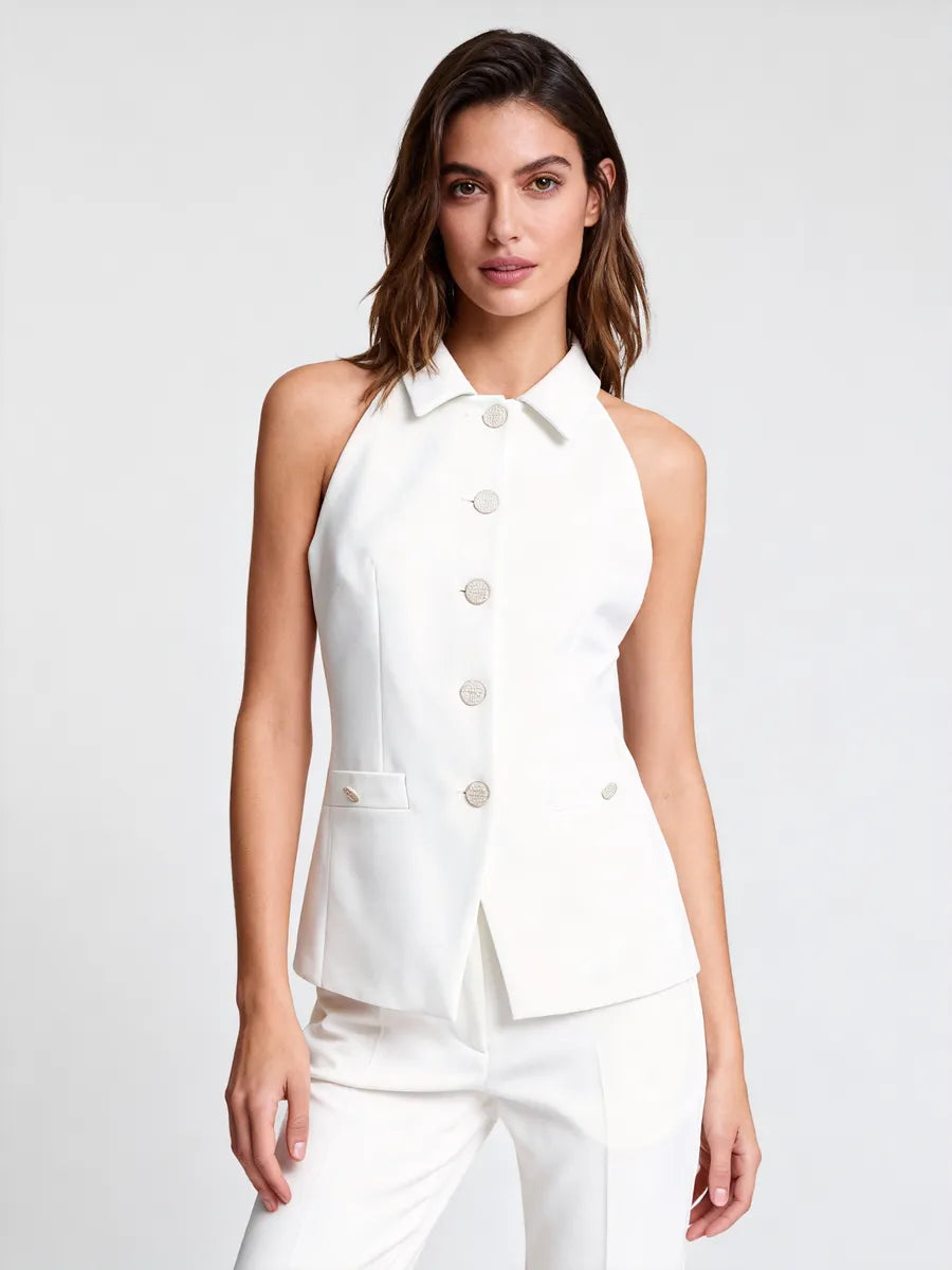 Woman wearing a white sleeveless blazer on a plain background