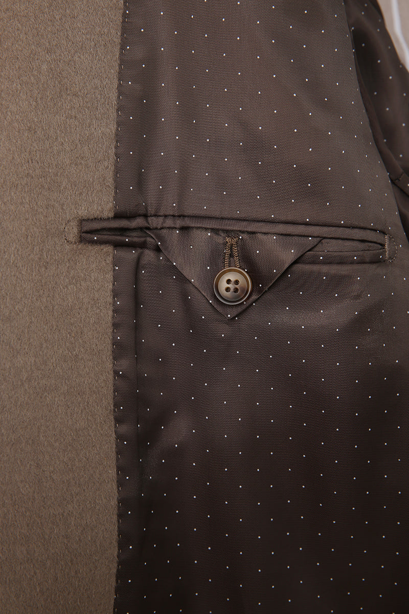 Close-up of a brown suit with a button and subtle pattern