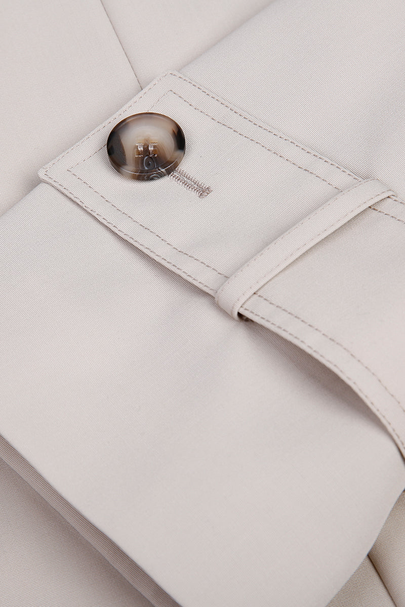 Close-up of a beige suit jacket with a button and strap detail. custom made jackets for her