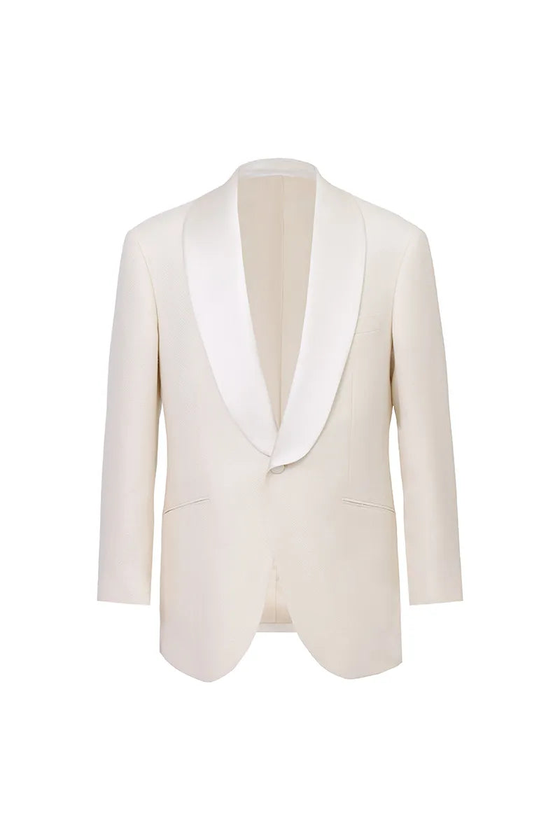 Off-white tweed tuxedo suit for men featuring a shawl collar jacket and matching trousers in a subtle herringbone texture. Luxury formalwear crafted from a premium wool, bamboo, linen, and silk blend with a soft hand feel and elegant appearance. Ideal for weddings, groom attire, destination weddings, black tie events, formal receptions, gala dinners, and upscale celebrations. Made-to-order men's tuxedo available in standard sizes and custom sizing options with nationwide shipping available.