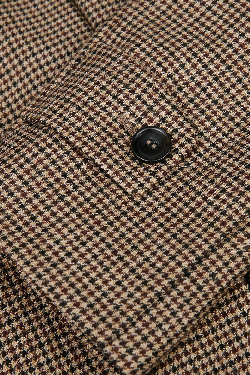 Close-up of a houndstooth patterned fabric with a button.