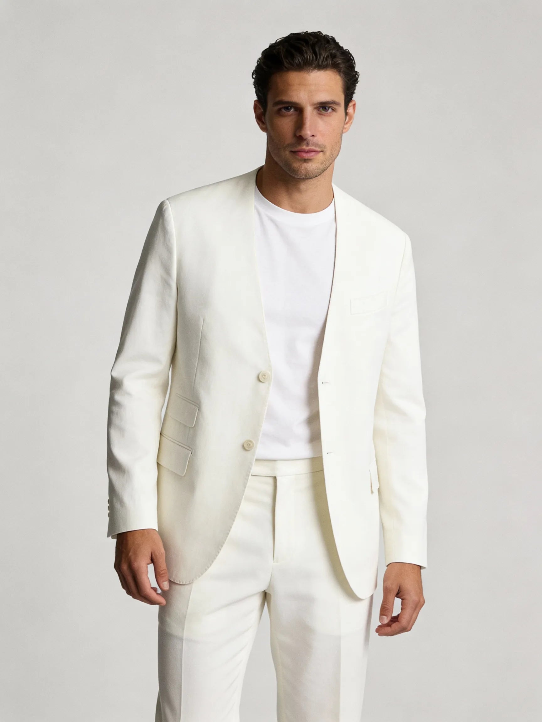Man wearing a white suit against a plain background