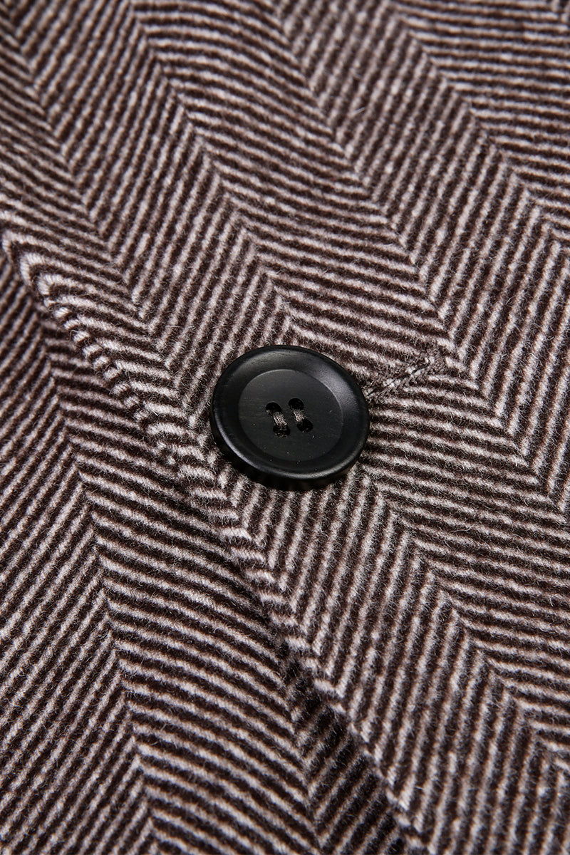 Close-up of a textured fabric with a button, featuring a herringbone pattern.