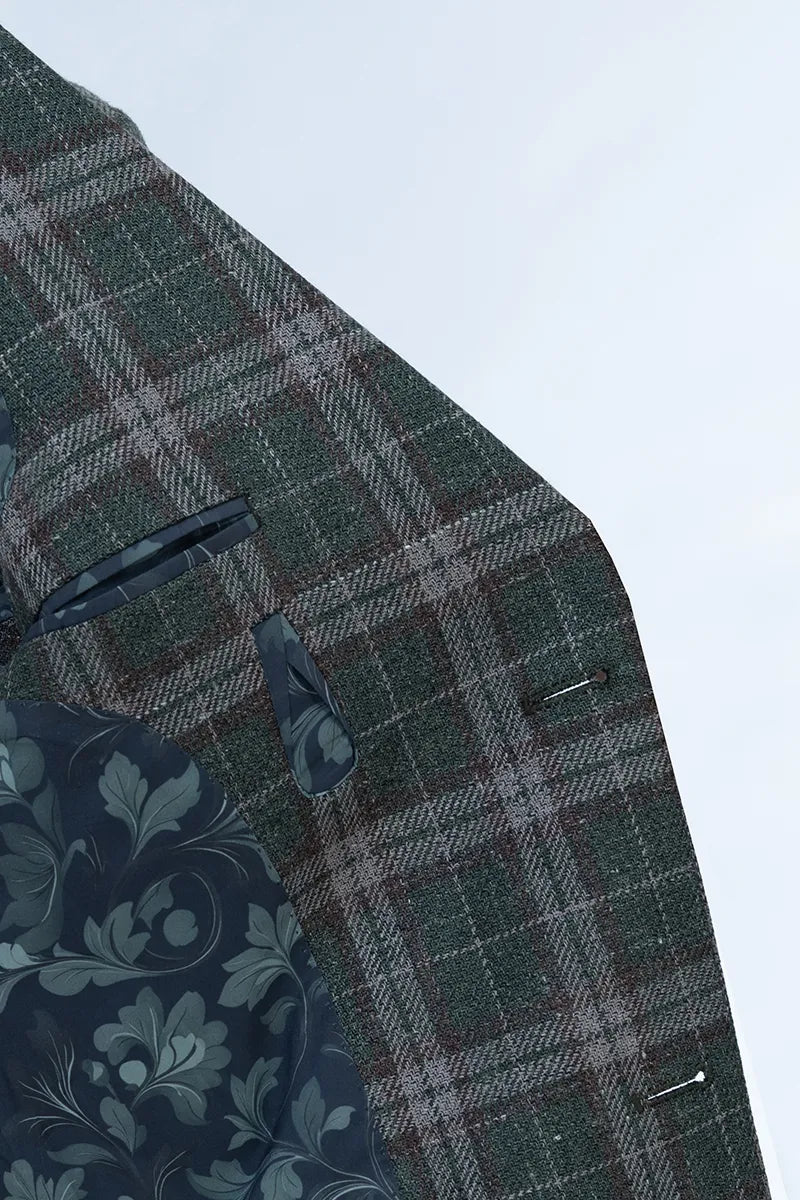 Close-up of a green plaid fabric with a floral patterned fabric partially visible. tailored suits and blazer online