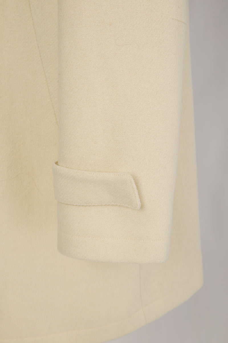 Close-up of a beige blazer with a pocket on a light gray background