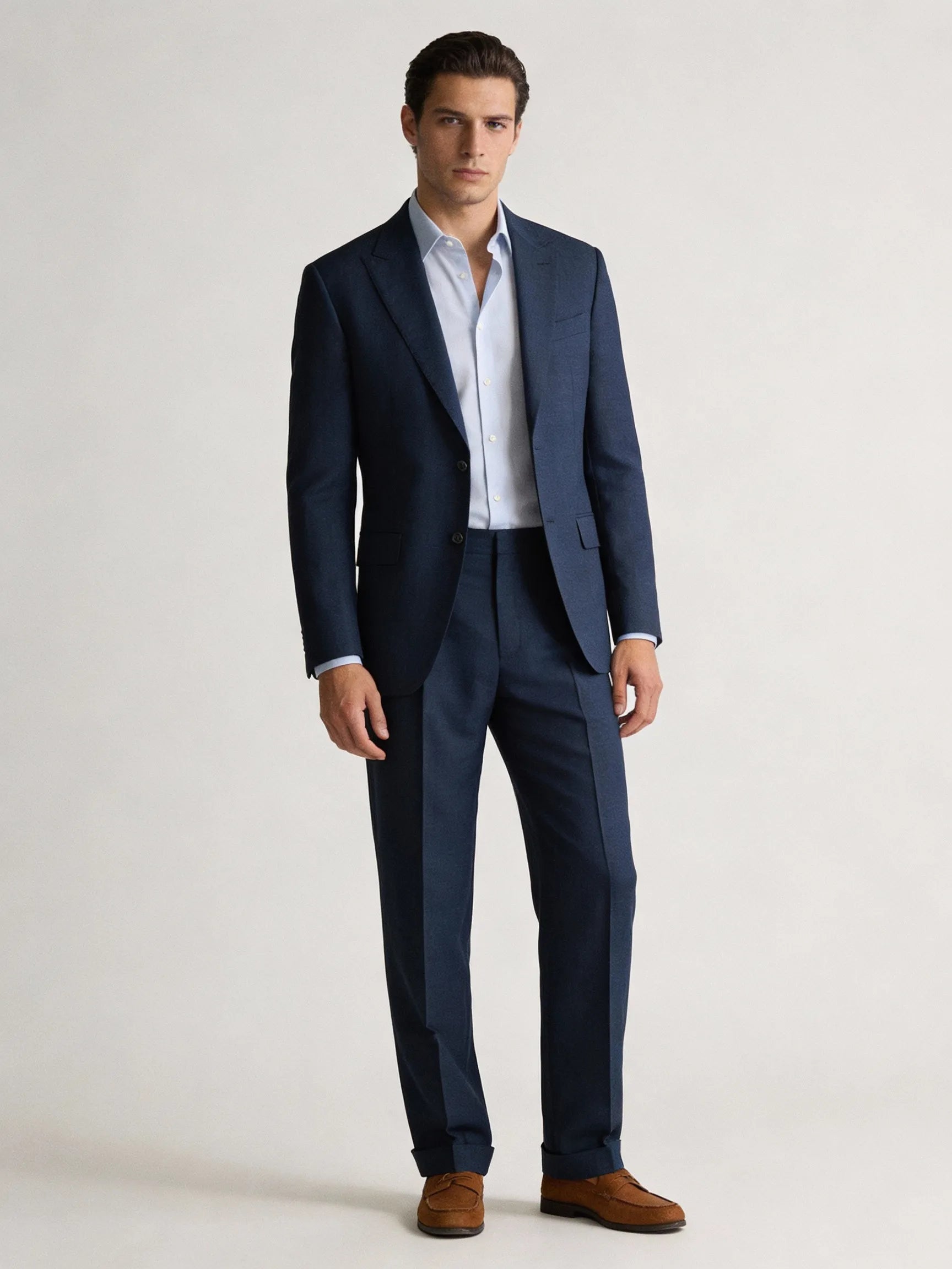 Man wearing a navy suit with a white shirt on a light gray background online suits for men italian suits