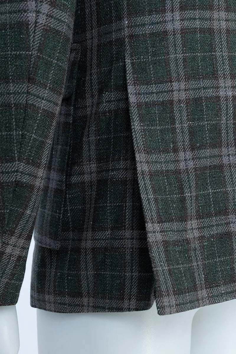 Close-up of a plaid coat with green and brown pattern on a white background
