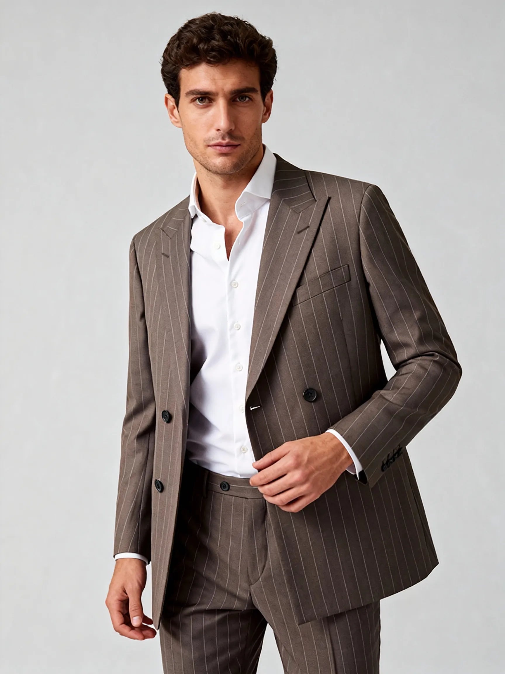 Man wearing a brown pinstripe suit with a white shirt on a light gray wool blend suit bespoke  itailored suit